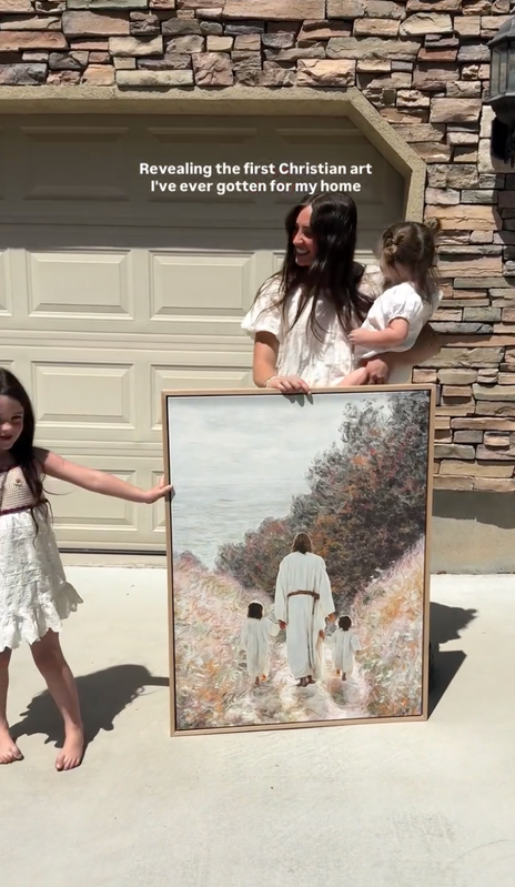 Steph and her children revealing framed artwork outdoors